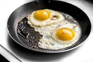 close-up shot of fried eggs on black pan