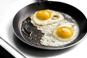 close-up shot of fried eggs on black pan