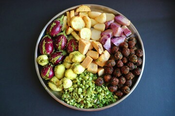 Mixed cut and marinated vegetables for Undhiyu. stuffed brinjals, fried potatoes, sweet potatoes, purple yam. preparation for surti undhiyu Indian Gujarati dish. Makar Sankranti Special Dish.