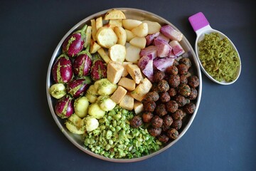 Mixed cut and marinated vegetables for Undhiyu. stuffed brinjals, fried potatoes, sweet potatoes, purple yam. preparation for surti undhiyu Indian Gujarati dish. Makar Sankranti Special Dish.