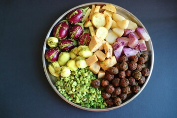 Mixed cut and marinated vegetables for Undhiyu. stuffed brinjals, fried potatoes, sweet potatoes, purple yam. preparation for surti undhiyu Indian Gujarati dish. Makar Sankranti Special Dish.