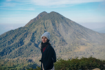 Fototapeta na wymiar portrait of a tourist girl in front of mount merapi on ijen volcano trail, indonesia