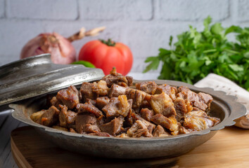 Muslims Traditional Sacrifice holiday food lamb, Turkish roasted meat in copper pot on table top. Turkish Kavurma. (Turkish name; Kurban kavurma)