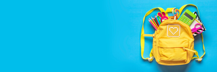 Back to school, education concept Yellow backpack with school supplies - notebook, pens, eraser rainbow, numbers isolated on blue background Top view Copy space Flat lay composition Banner