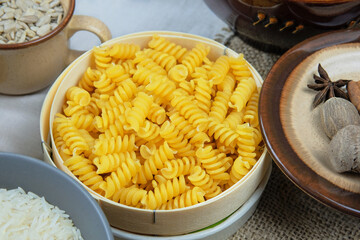 Pasta in straw bowl on a rural background. Vegetarian organic product.
