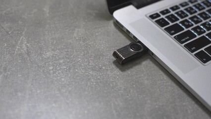 Connect a usb flash drive key to the port of a laptop pc computer.