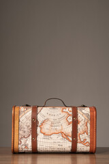 Wooden retro suitcase with world map on it.Vertical photo