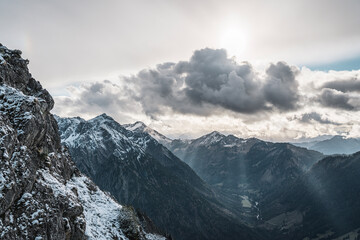 Obraz premium Scenic mountain view with snowcapped mountains under a cloudy dramatic sky