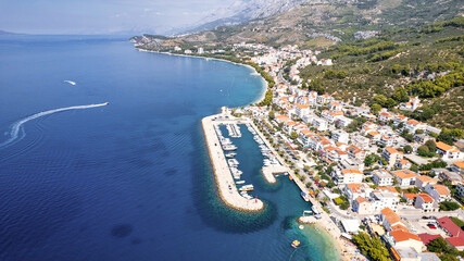 Panorama of Baska Voda town with harbor against mountains in Makarska riviera, Dalmatia, Croatia