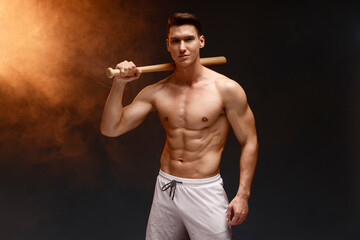 Image of baseball player with bat posing at the camera with serious face