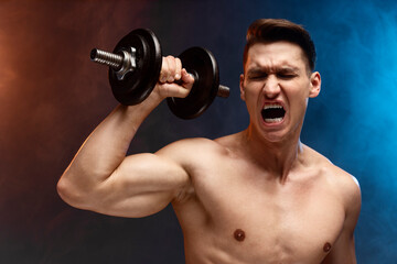 Fototapeta na wymiar Handsome sportive strong-willed naked guy building muscles on arms by lifting dumbbells