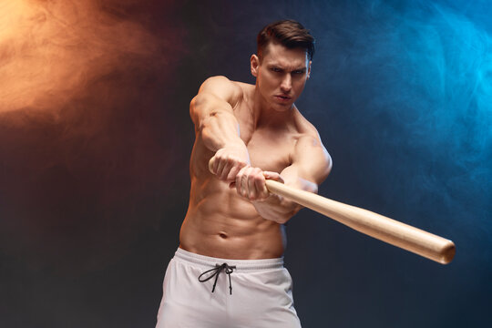 Image of baseball player with bat posing at the camera with serious face