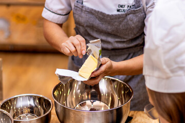 Female pastry chef picking up butter for cookie recipe