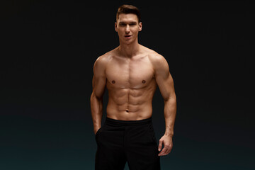 Strong athletic man fitness model posing with naked torso showing six pack abs