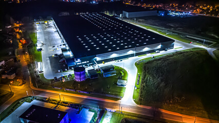 Aerial view of goods warehouse night. Logistics delivery; center in industrial city zone from...