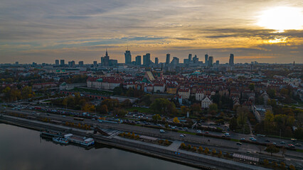 Naklejka na ściany i meble Warsaw at sunset. The capital of Poland is illuminated by a beautiful orange sun. Panorama of Old Town and downtown