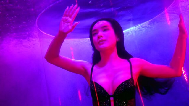 portrait underwater of beautiful fashion model with long dark hair, woman is diving in water