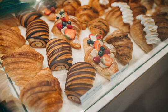 Different kinds of pastry on a platter such as crossaint and cinnamon rolls with chocolate