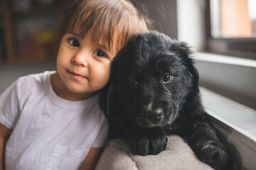 Cute little girl hug and play with her puppy
