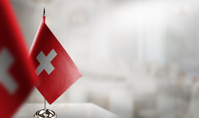 Small flags of the Switzerland on an abstract blurry background