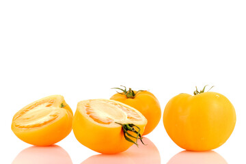 Two halves and two whole organic juicy, yellow tomatoes, close-up, on a white background.