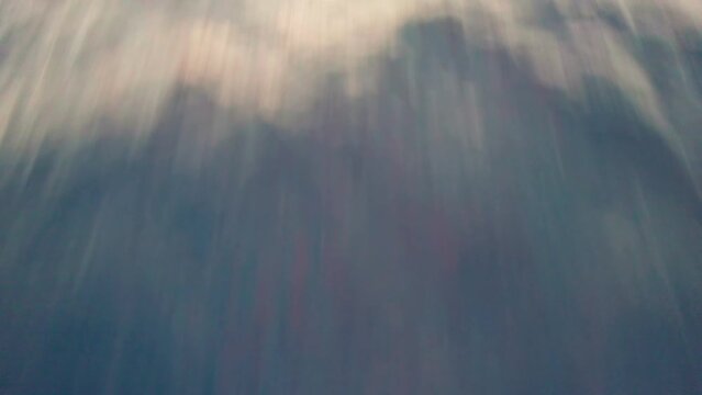 Flying over the sea at sunrise. Pink orange light on the water waves.