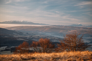 Fototapeta na wymiar Beautiful sunrise in mountains with white fog below panorama