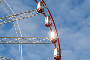 Colorful ferris wheel cabins view with sunbeam in central park, Kharkiv city. Amusement attraction...