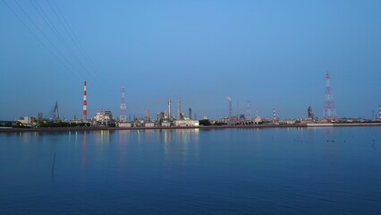 青々とした空と海に挟まれた工場の夜景