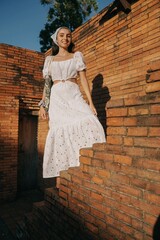 girl in a white dress on the old brick stairs.