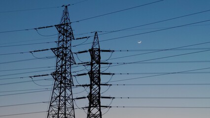 三日月が照らす夜空に佇む鉄塔のシルエット