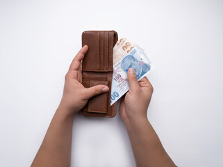 Man's hands putting money in wallet isolated on white background.Minimum wage increase,raise,news