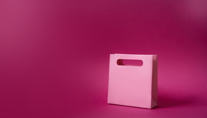 sale concept. Shopping bag isolated on pink plain neutral background, christmas gift valentines day birthday girl presents, black friday, cyber monday. Horizontal photo, copy space, shop, on the side