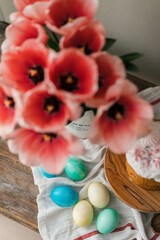 Easter symbols colored eggs and Panettone. Pink tulips in a metal jug. Easter holidays decorations 