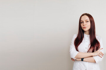 portrait of young attractive female doctor in white coat, copy space