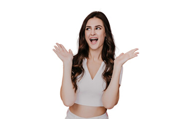 Fototapeta na wymiar Amazed young brunette woman in white t-shirt, pants rises up hands looks aside, opens mouth with surprised face expression over transparent background. People's emotions. Mockup, sale, discount, promo