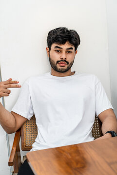 Mockup image of a young bearded man doing a pose while wearing white blank shirt