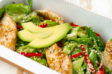 chicken salad with avocado in a Take away box. Healthy lunch