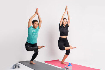 Obraz premium asian couple practicing yoga with body balance exercise movements on isolated background