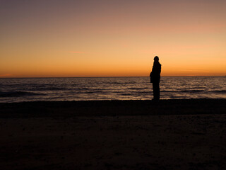 Fototapeta na wymiar person walking on the beach at sunrise
