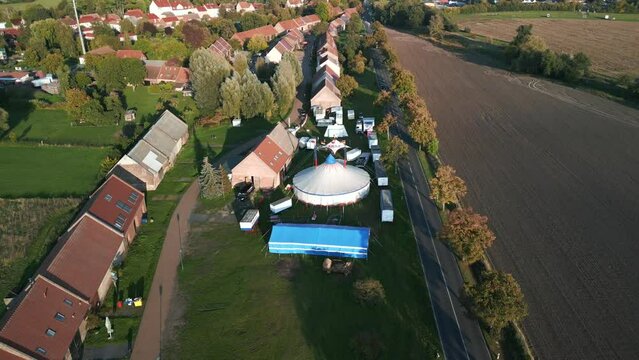 circus tent on road in small village kremmen. Lovely aerial view flight bird's eye view drone
brandenburg golden houre 2022. 4k marnitz Cinematic