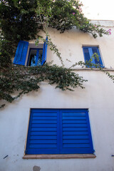 Pequeña casa blanca con sus ventanales azules escondida en una de la estrechas calles del pueblo...