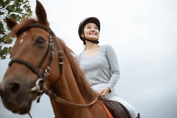 Foto op Canvas beautiful woman equestrian athlete practicing horse riding on outdoor background © Odua Images