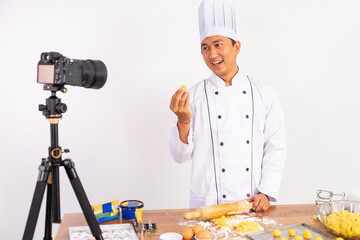 male chef food vlogger presenting cake to camera while baking cake with isolated background