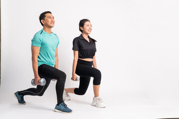 Obraz premium side view of man and woman squatting with dumbbells in both hands on white background
