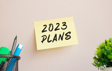 The sticker is glued to the wall in the office. There is a reminder on the sticker. 2023 PLANS text is handwritten.