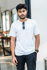 Mockup image of a young bearded man doing a pose while wearing white blank shirt