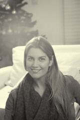 Happy woman at home for holiday season with Christmas tree on the background