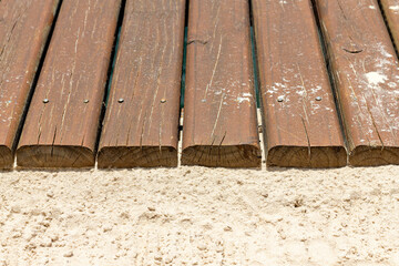 Closeup of wooden sidewalk over sand floor