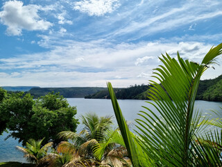 Beautiful view of the huge lake on a blue sky day with vegetation in the foreground